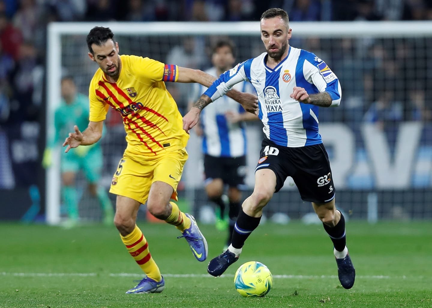 Sergi Darder conduce el balón ante la presencia de Sergio Busquets, en ElDerbi de Barcelona de la temporada pasada en el RCDE Stadium - Foto: LaLiga.